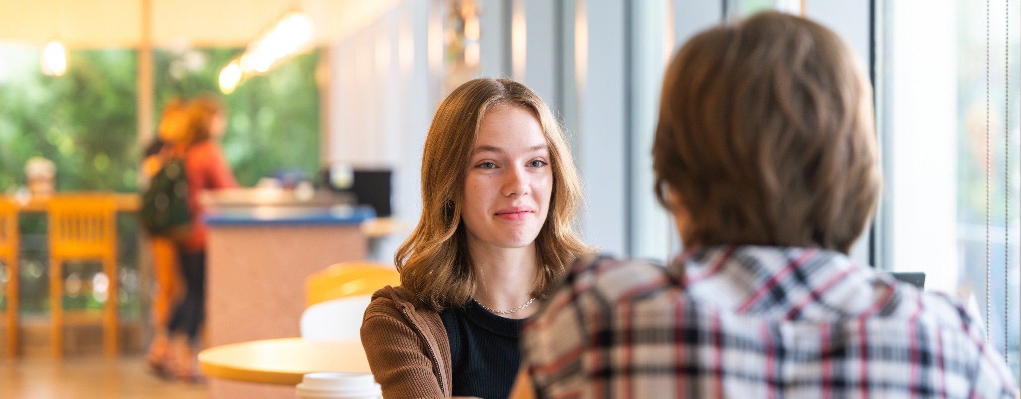 A student talks to another student in the Michigan Tech Library.