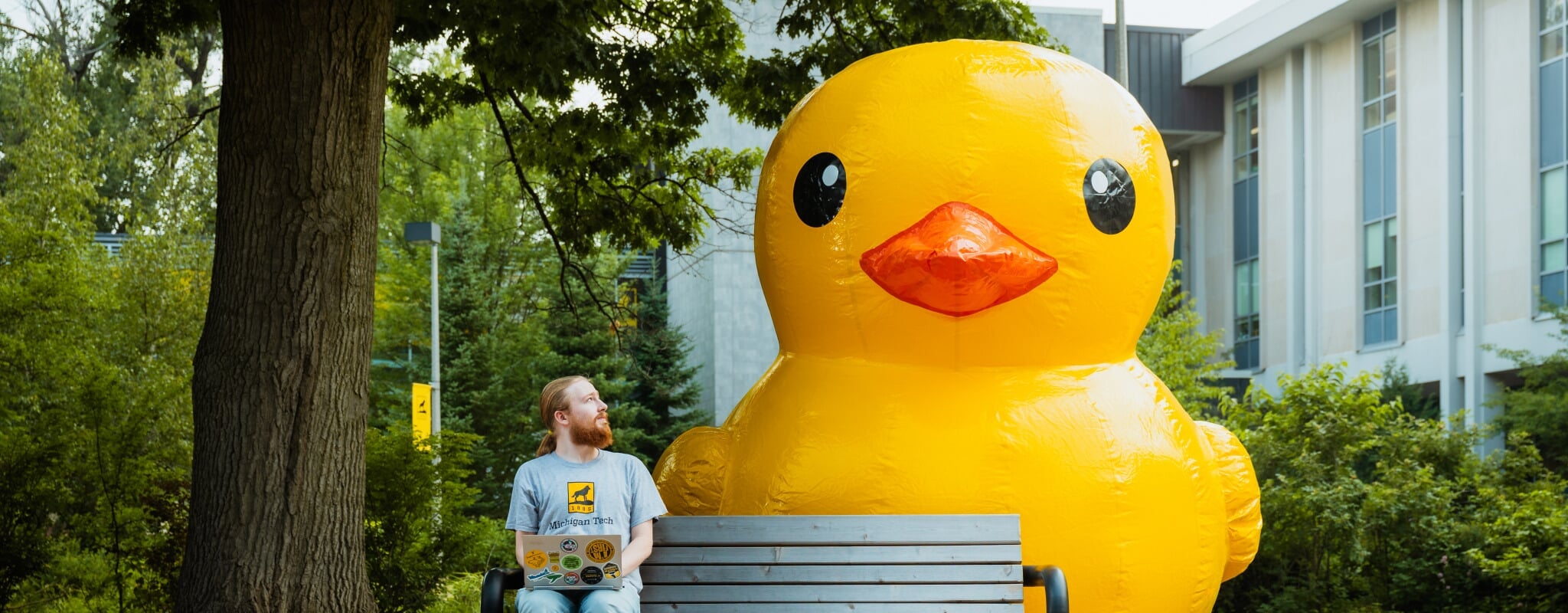 student looking up at giant rubber duck