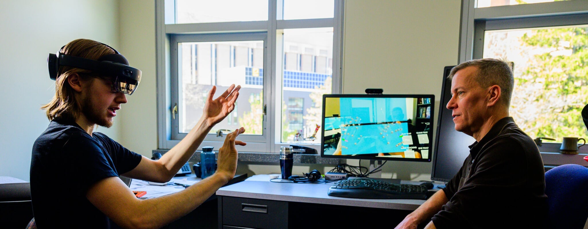 professor with student who's using piece of technology