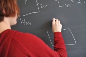Student writing on a blackboard