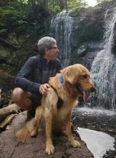 Michael Meyer with golden retriever next to waterfall