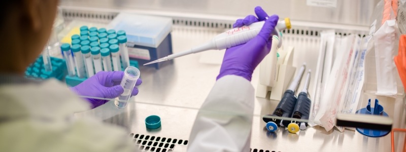 Yoke Khin Yap pippetting a solution into a screw on tube in his laboratory