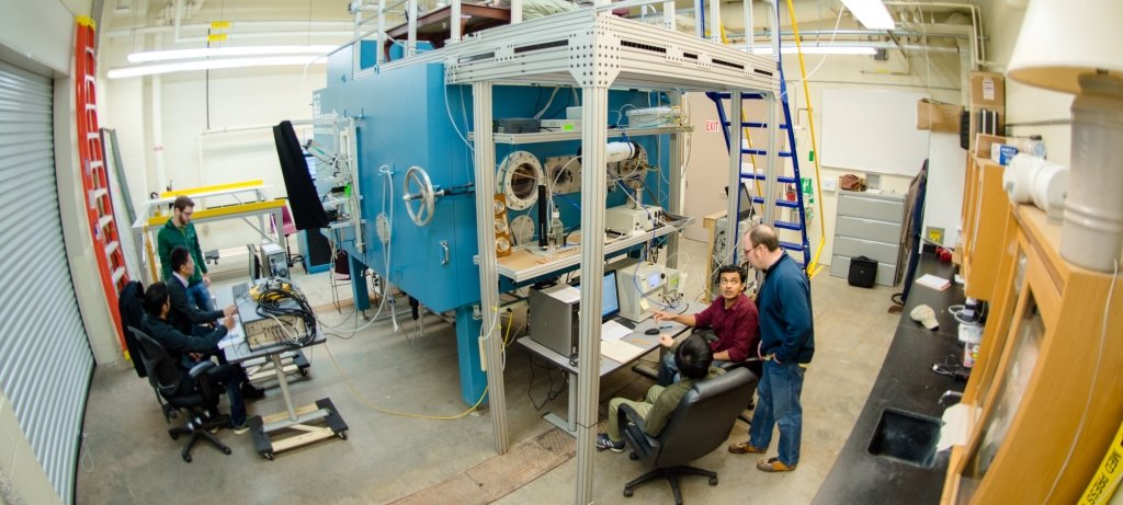 Researchers working at computers around the Cloud Chamber in the Cloud Chamber lab