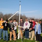 Group of physics students testing equipment in a field.