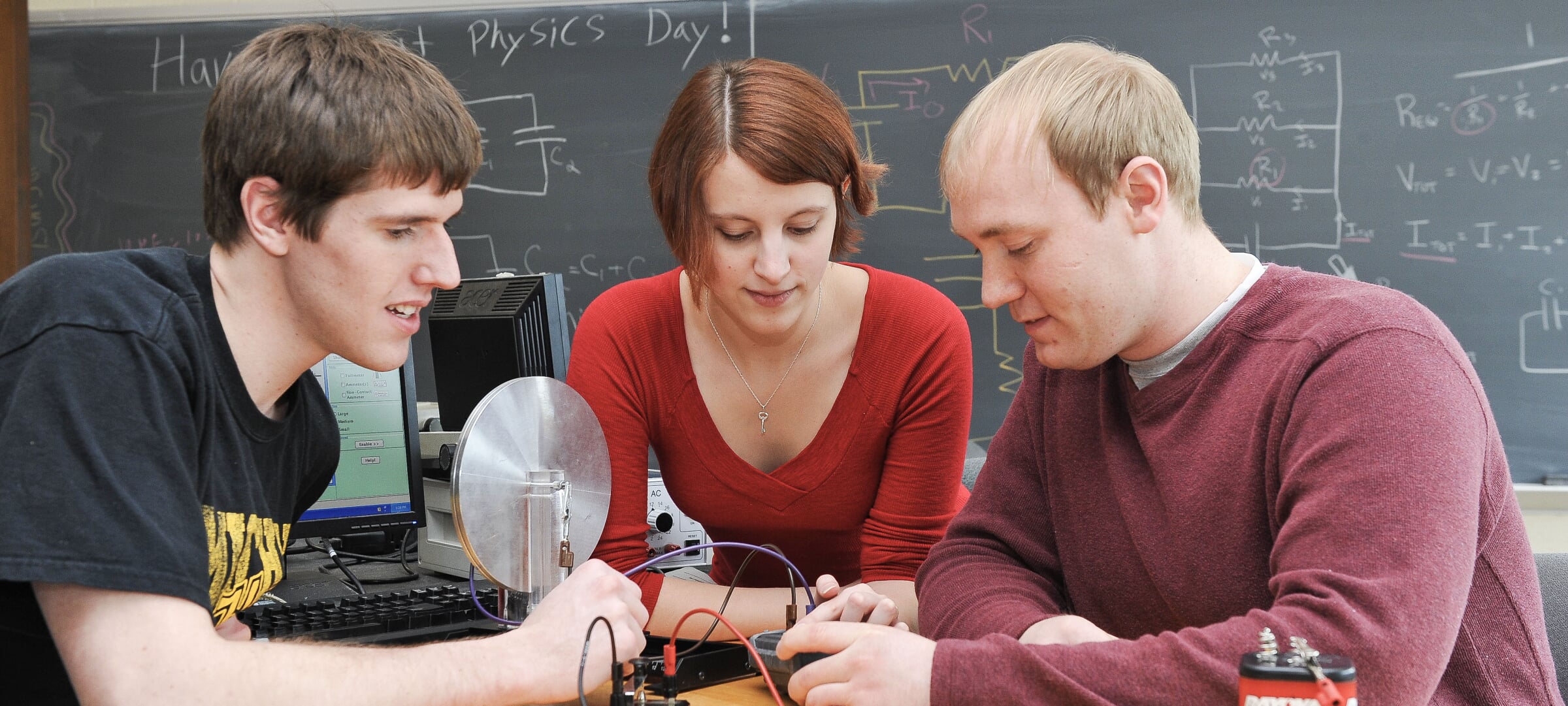 Three physics students operate an electronics test