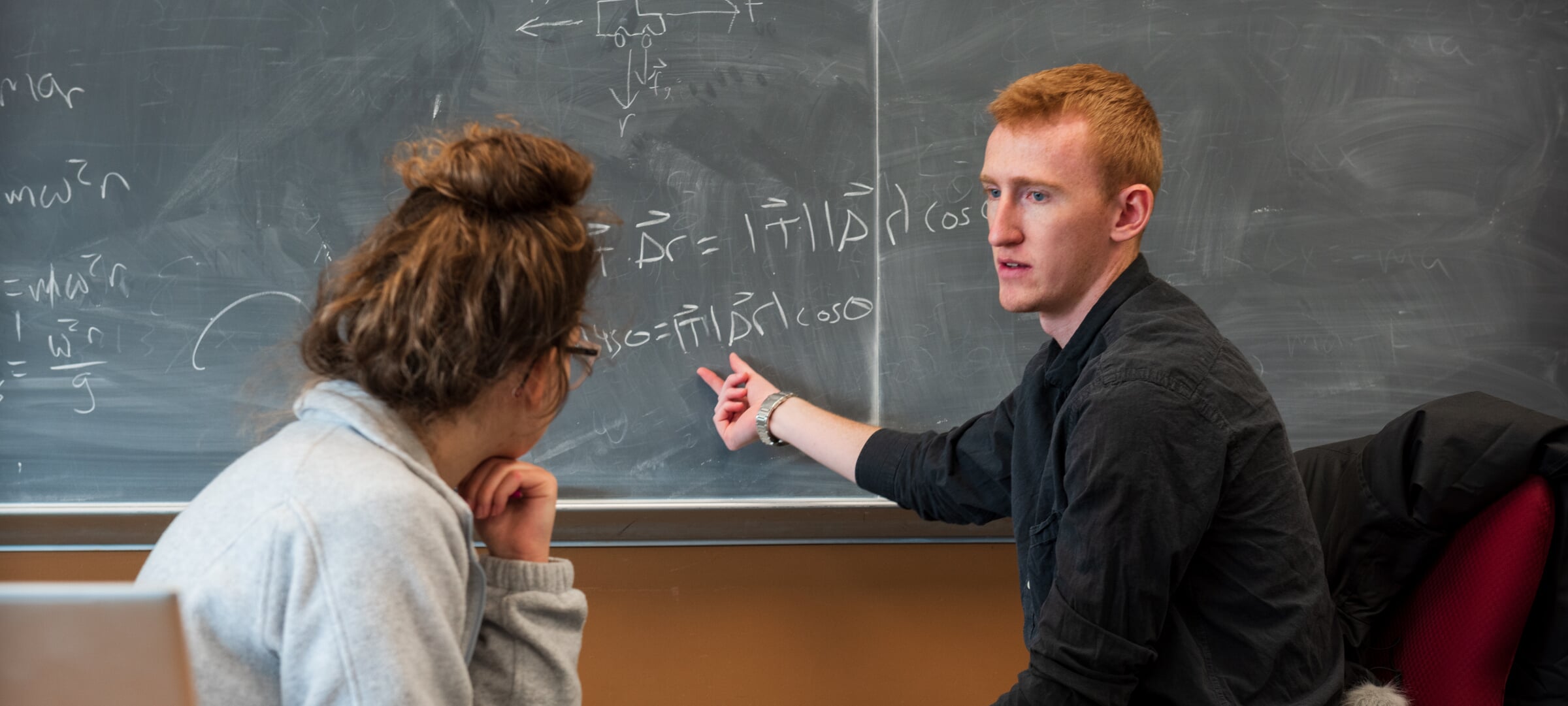 Discussing physics on a chalkboard