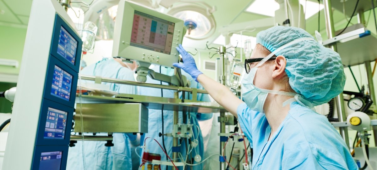 Image of a Cardiovascular Perfusionist in the operating room monitoring patient vital signs on a screen.