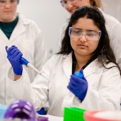 Student holding a pippet and looking at a bottle