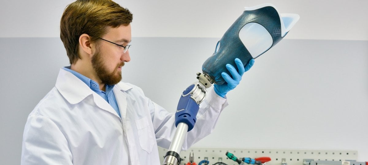 Image of a male prosthetist inspecting an artifical leg