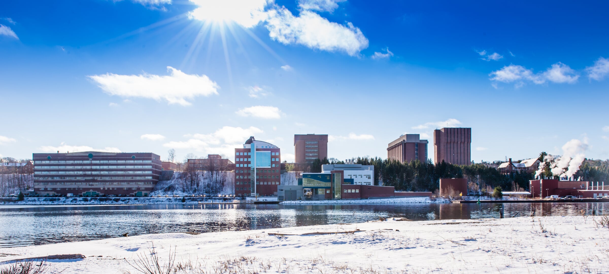 Michigan Tech campus from across the Portage waterway on a clear, sunny, winter day.