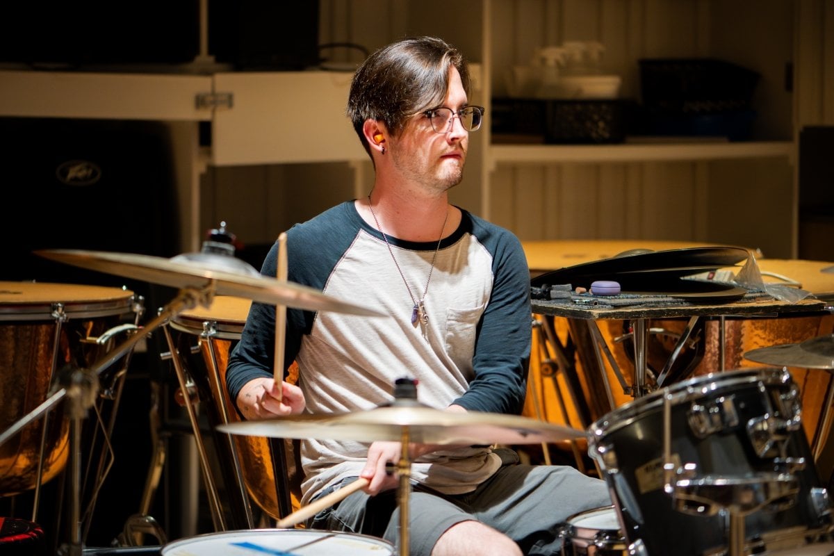 Take part in or enjoy visual and performing arts opportunities. Student playing the drums.
