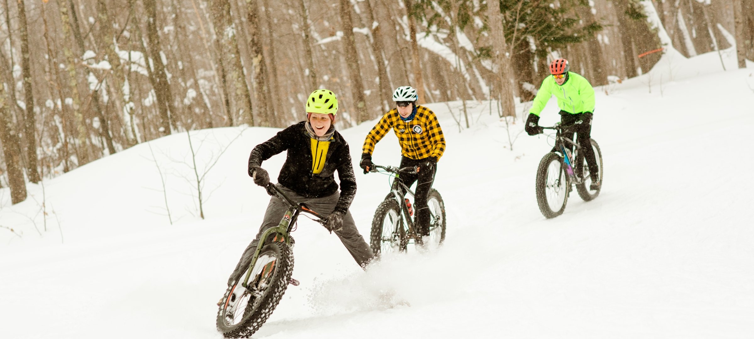 Three people snow biking.