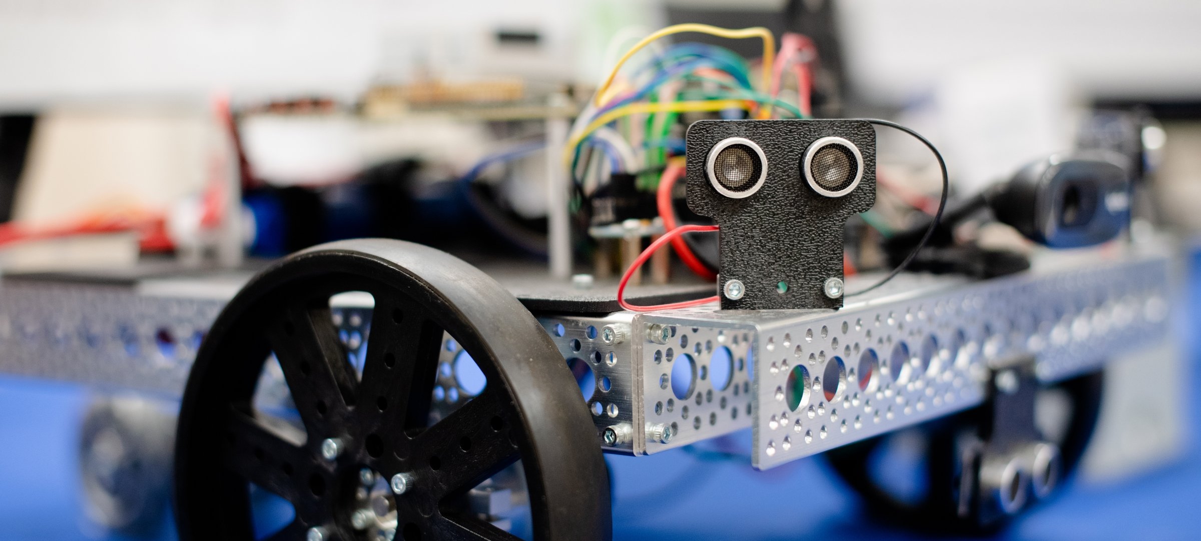 A small robot drives across a room.