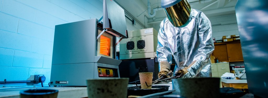 Person in protective suit using lab equipment