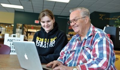 Female student working with Chalres Wallace on a laptop