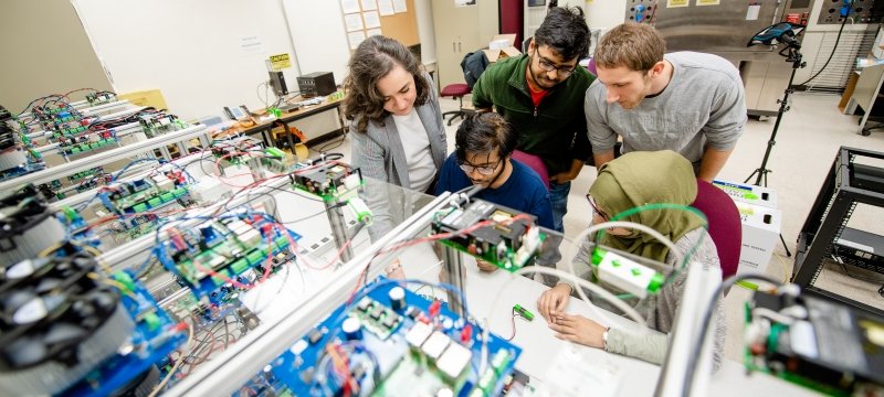 Researchers in the battery lab looking over a battery.