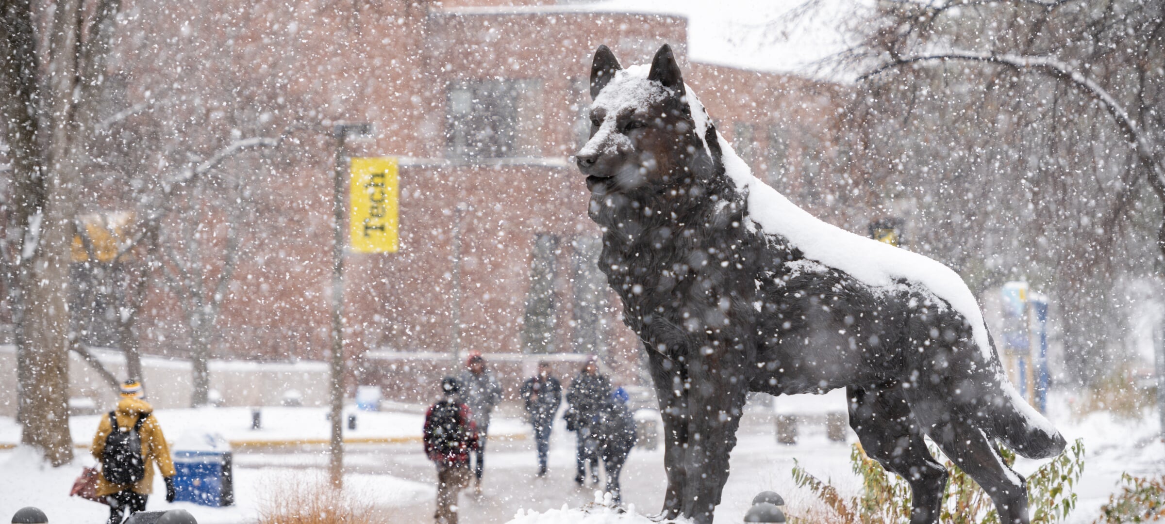 Image of campus with students walking and Blizzard statue