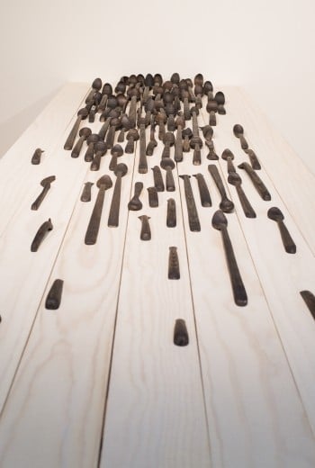 Art piece, spoons of differing sizes on a table