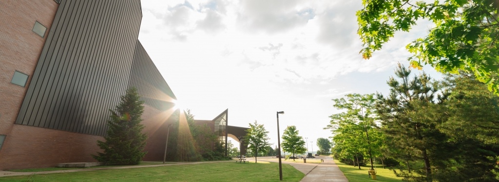 Outside the Rozsa Center with the sun rising from the top of the building.