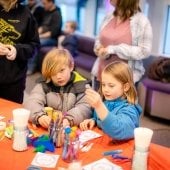 Two children make arts and crafts at a table.