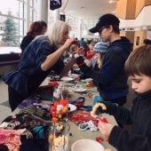 Four children create puppets at the sock-puppet creation station.