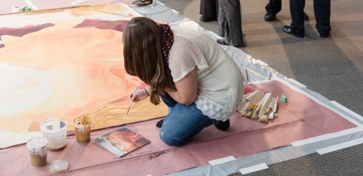 Artist paints on a large canvas in the Rozsa Galleries. 