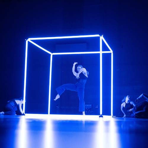 A Water Street Dance Milwaukee performer dances in the center of a glowing cube.