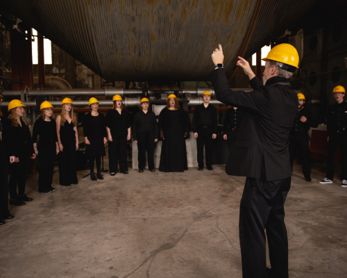 conScience performs in the Quincy Mine Hoist House wearing hard hats.