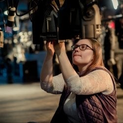 Student sitting on the floor working with lighting above