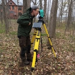 Student using archaology equiptment behind Quincy Mine.