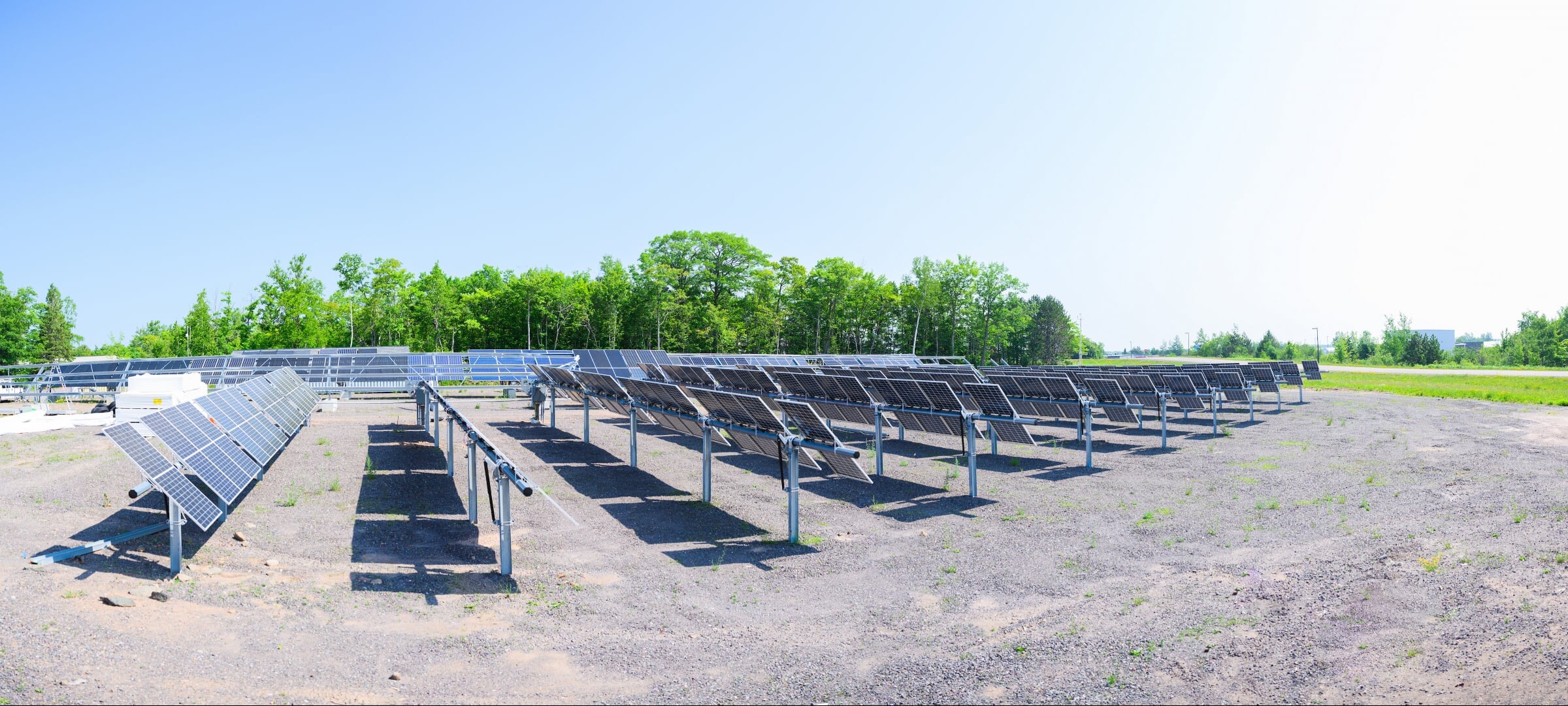 Solar panels in a gravel lot on a sunny day
