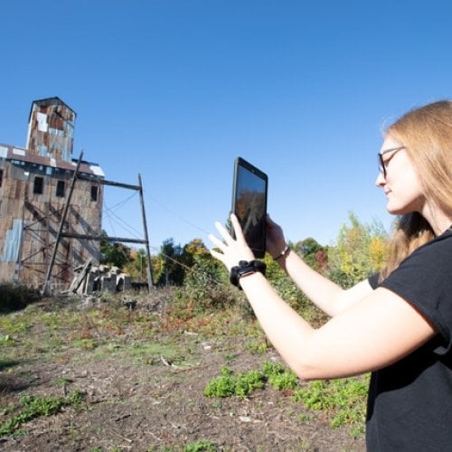 Image of Michigan Tech student using augmented reality to see how industrial landscapes have changes over time