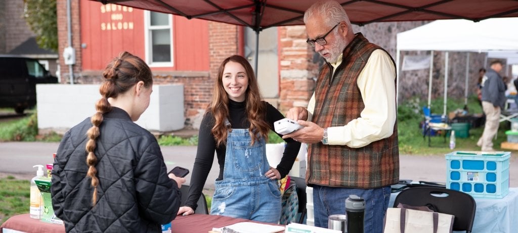 Image of sustainable communites student working at a local farmers market