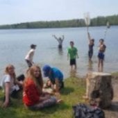 Image of college students inspecting shoreline by lake