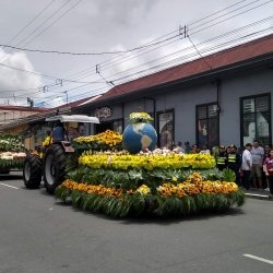 Parade float created from flowers and a large globe.