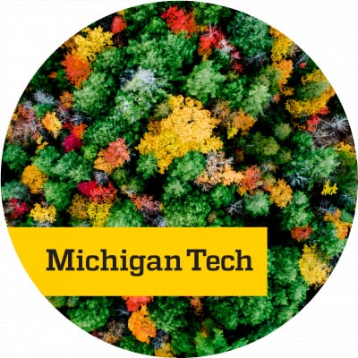 Looking down at multi-colored treetops with black text reading Michigan Tech on a yellow backdrop.