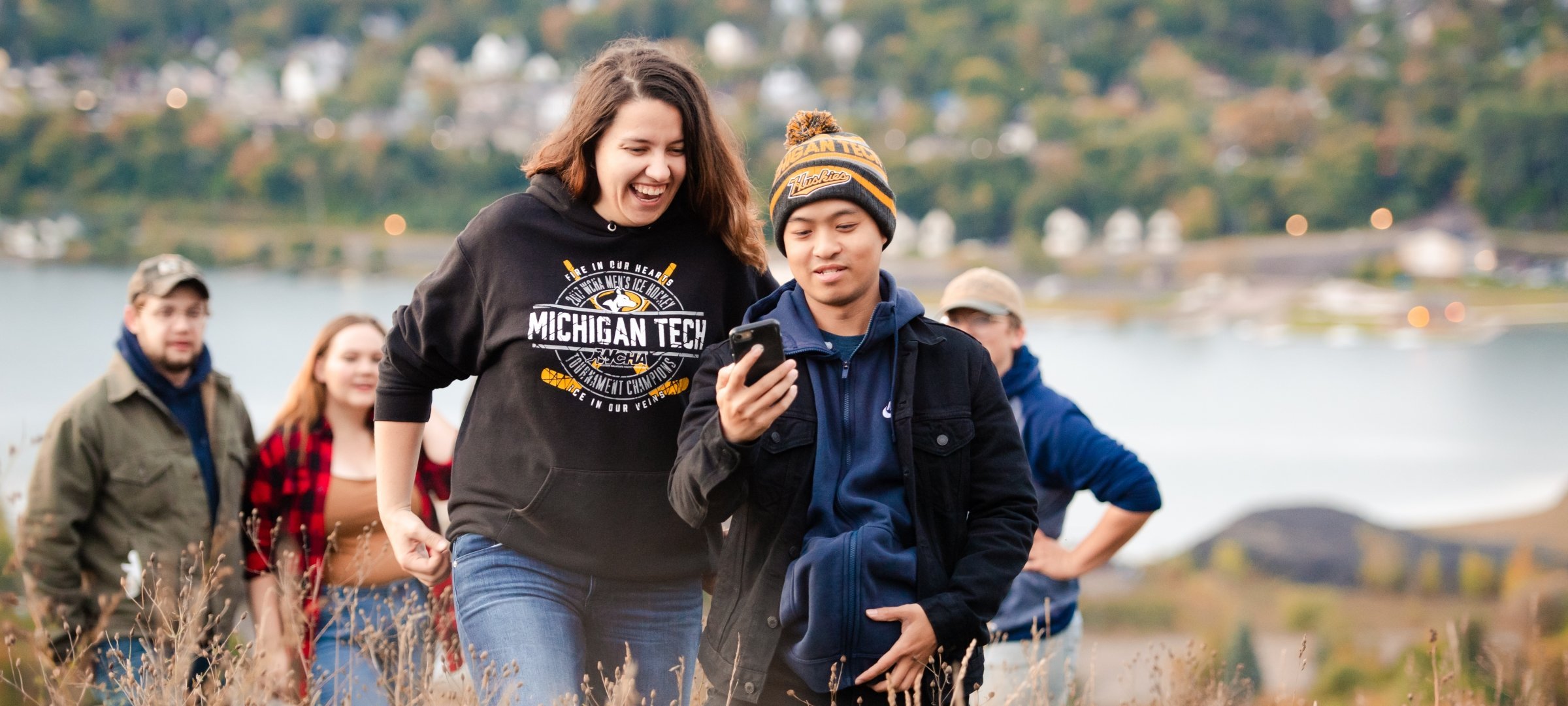 Students looking at a phone from on top of Mont Ripley