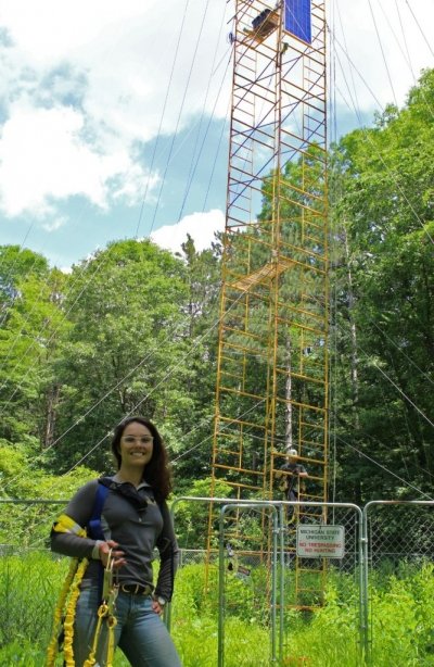 Gabriela Shirkey standing in front of a large scaffold with climbing equipment.
