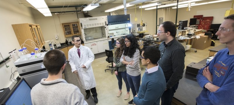 A professor in a Michigan Tech lab with seven undergraduate students