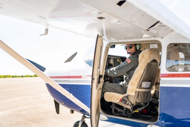 A pilot in a flight suit in his plane at Houghton Country Memorial Airport—he is a Michigan Tech ROTC cadet, too, and super active on campus.