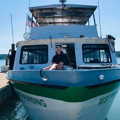 A young engineering student sits on the bow of the Lake Superior tour boat she works summers on in Munising, Michigan.