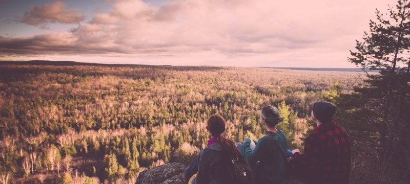 Three Michigan Tech students look out over the horizon in a forest ecology class.