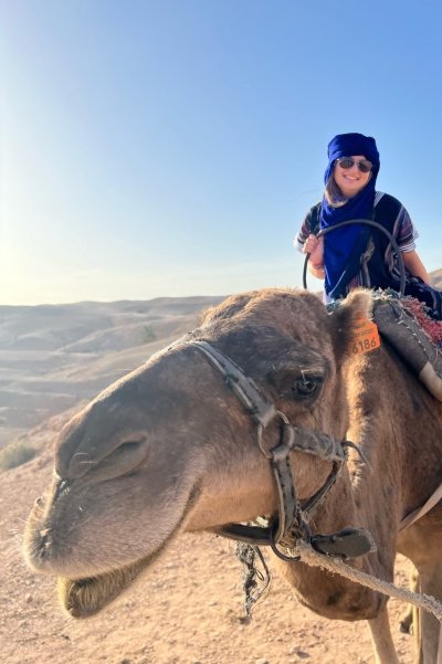 A young woman on Study Abroad rides a camel in Morocco