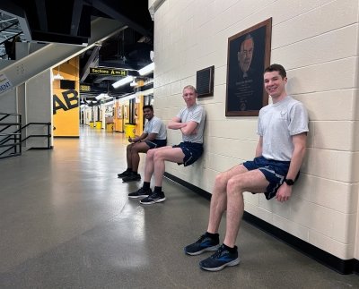 Michigan Tech AFROTC cadet Nick McKenzie does wall sits up at MacInnes Ice Arena with fellow cadets — he's smiling on the right.