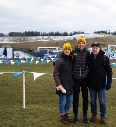 A Michigan Tech cross country runner at nationals in 2022 with his parents.