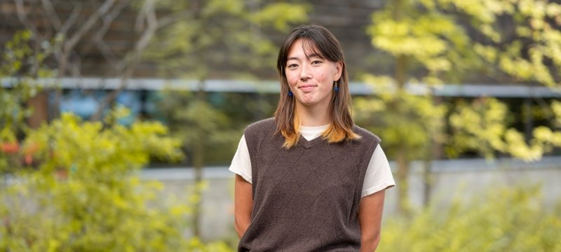 An Obama Foundation Voyager Scholar winner stands in front of the forestry building where she studies wildlife ecology, on the campus of Michigan Technological University