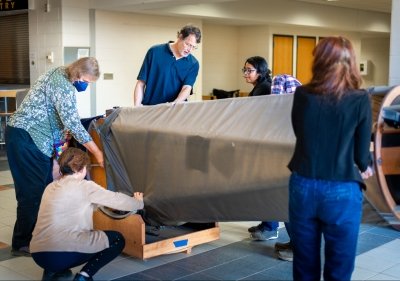 A professor and students move a giant telescope at Michigan Tech. Located in Fisher Hall, it is thought to be one of the largest of its kind in the world devoted solely to student use.