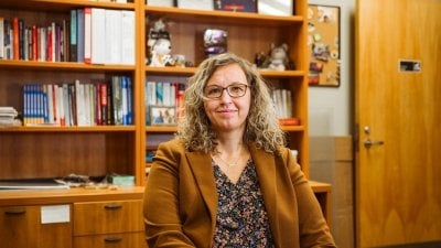 Kellie Raffaelli, dean of students, shown in her office with an open door and a bookshelf of MTU memorabilia and resources behind her, has been serving Huskies for 11 years.