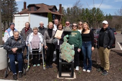Harju family poses behind copper boulder