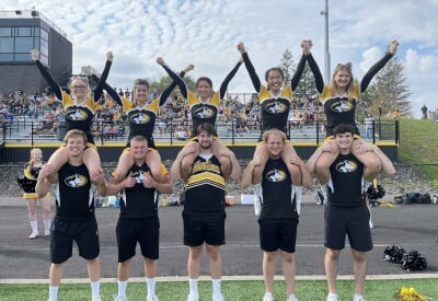 Five pairs from the cheer team with one person sitting on the other's shoulders.